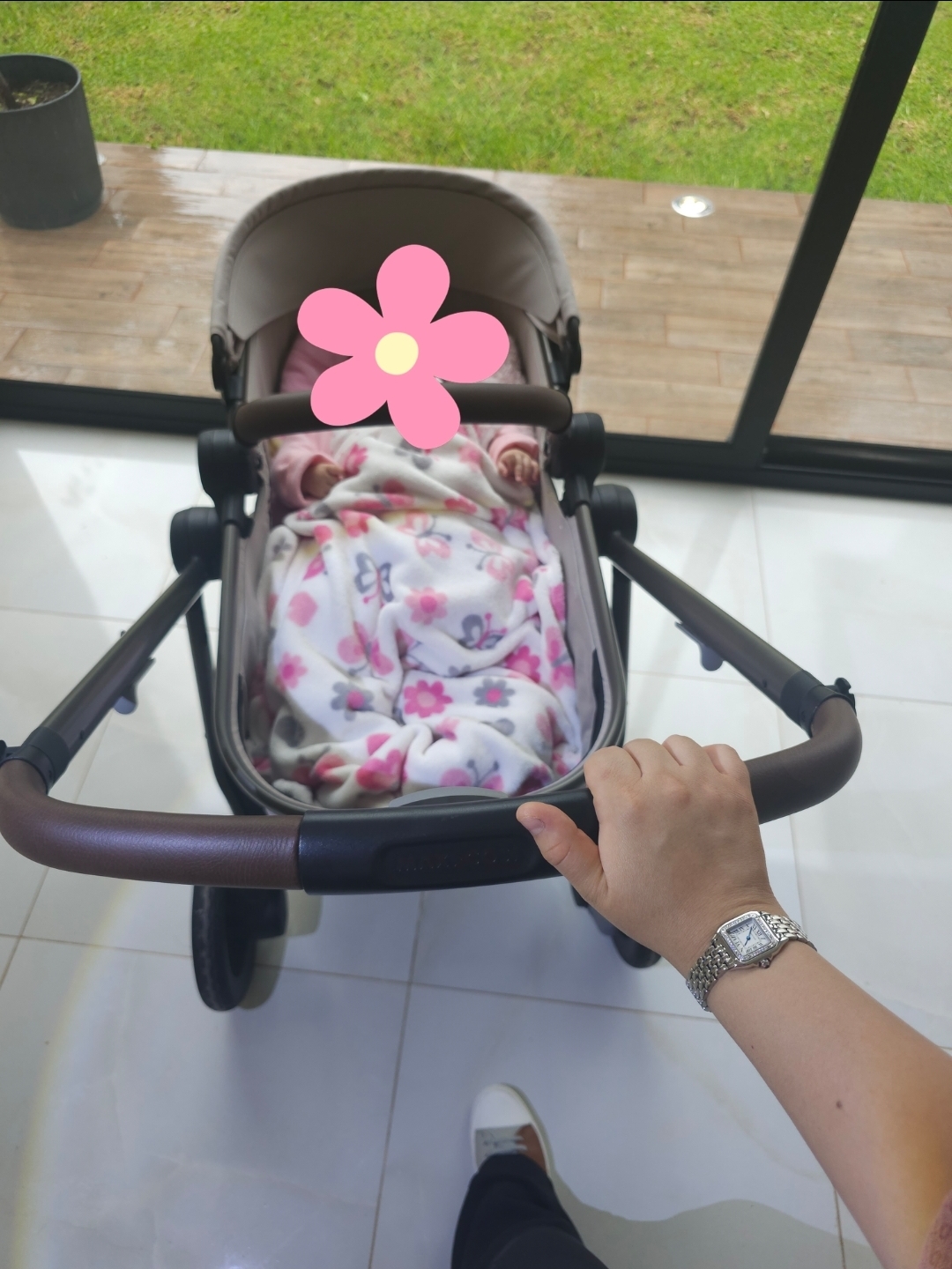 Amélie in her stroller, with her face covered by a flower